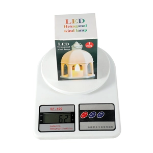 Weight measurement of white LED hexagonal Christmas lantern showing 62g on digital scale