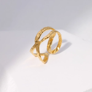 Close-up of golden double-layer cross ring with unique hammered metal texture finish