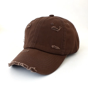 Detailed 45-degree angle of dark brown distressed vintage cotton baseball cap with worn holes