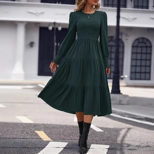 Detail of smocking on sleeves and bodice of elegant dark green tiered midi dress