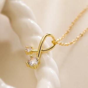 Golden necklace with double zircon geometric pendant in a minimalist infinity design