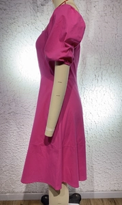 Detail of rose pink dress featuring puff sleeves and high waist tailoring on mannequin