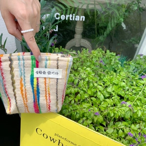 Detail of colorful striped fabric makeup bag with metal ring zipper and Korean text label