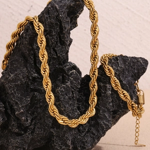 Macro view of gold-plated stainless steel rope chain with adjustable clasp on rock