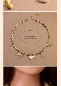 Detailed view of gold stainless steel necklace with butterfly and emerald charms