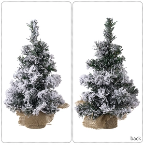 Detail of mini snow-flocked Christmas tree with burlap base and needle texture