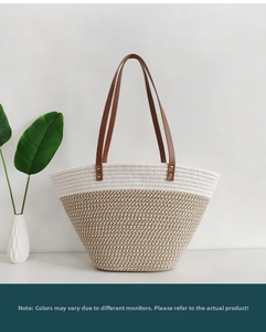 Detail of contrast woven tote bag with brown leather handles and gold rivet accents