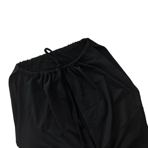 Close-up of drawstring detail and ruched fabric on a slim black dress for women