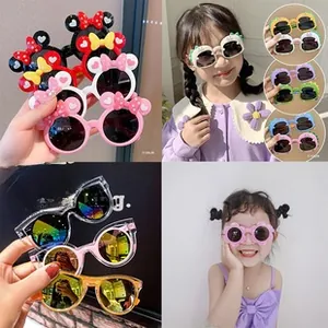 Close-up of colorful cartoon children sunglasses featuring flower and dinosaur frames
