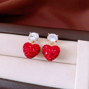 Gros plan de boucles d'oreilles cœur avec strass rouges et zircon dans un coffret cadeau
