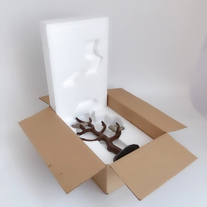 Rustic tree jewelry stand with bird detail in protective foam packaging