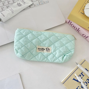 Vue détaillée du motif matelassé vert menthe et de l'étiquette de marque tissée du sac