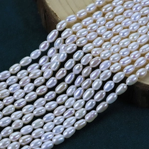 Macro detail of high-luster white natural freshwater rice pearls on a wooden stand