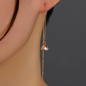 Detail of gold tulip tassel earrings with sparkling cubic zirconia on a female model