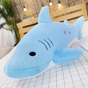 Detail view of cartoon blue shark plush toy skin with high quality embroidery in cozy bedroom