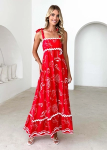 Detail of red floral maxi dress with white wavy trim and Ciao print for beach vacation