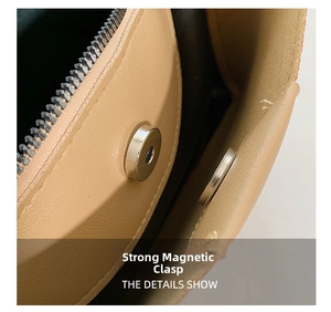 Detail of light brown handbag showing strong magnetic closure and smooth metal zipper mechanism
