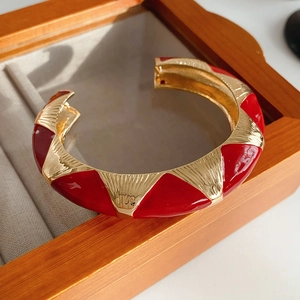 Detail of French vintage gold bangle with red enamel inlay and pleated texture