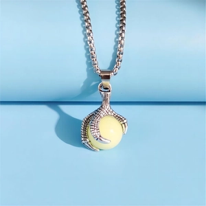 Close-up of vintage dragon claw necklace with pale yellow luminous bead and box chain