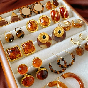 Retro geometric resin earrings in amber and tortoiseshell patterns on a jewelry tray