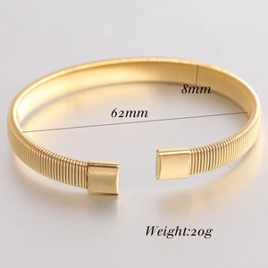Detail view of 8mm gold elastic spring bangle showing the screw texture and dimensions