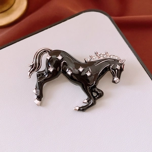 Macro detail of galloping horse brooch with black enamel finish and sparkling crystals