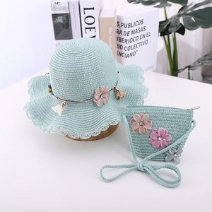 Detail of mint green straw sun hat and matching bag set with floral accents