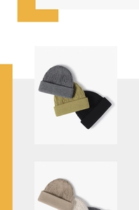 Detail view of various colored cable knit beanies with a classic folded cuff design