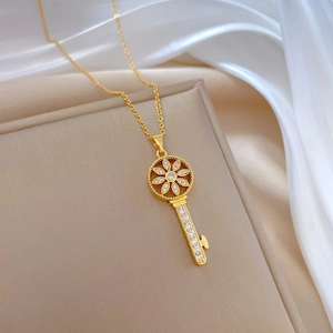 Macro shot of gold starburst key pendant with pave crystals on beige jewelry box
