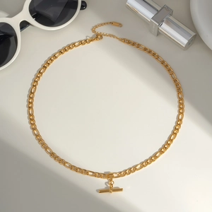 Close-up of gold-plated Figaro chain with T-bar pendant and S.Steel engraving detail