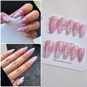 Vue détaillée des faux ongles amande avec nœud rose motif léopard et perles