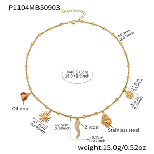 Detail view of a gold beaded necklace with ladybug and heart charms made of stainless steel