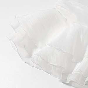 Macro shot of layered white chiffon ruffles and fine stitching on a stylish skirt
