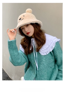 Close-up of light beige plush bucket hat with bear ears and cable knit cardigan