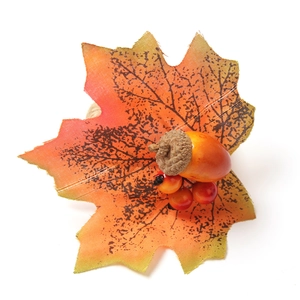 Close-up of autumn napkin ring with maple leaf, acorn and berries for table decor