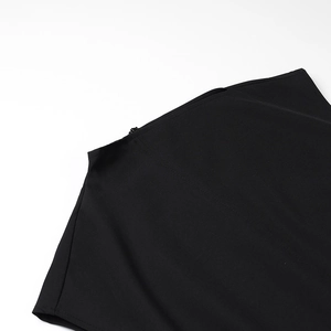 Detail shot of the invisible zipper and fine shoulder stitching on black midi dress