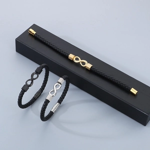 Three men's infinity leather bracelets in gold, silver, and black colors on a gift box