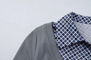 Détail du tissu gris côtelé cousu avec un col polo à carreaux bleus pour haut élégant