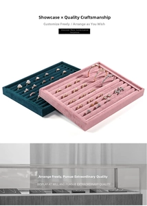 Detail of velvet jewelry display trays with multiple slots in pink and dark teal colors