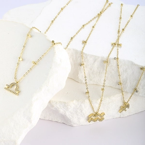 Macro shot of gold zodiac necklaces with sparkling cubic zirconia on white display