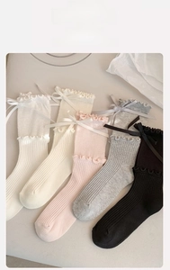 Detail of ruffled cuffs and ribbon bows on multi-color Lolita style crew socks