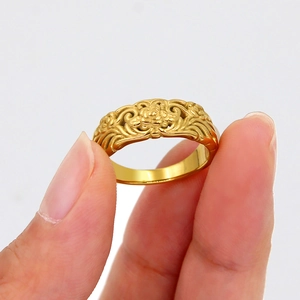 Minimalist gold stainless steel ring featuring vintage floral embossing held on fingers