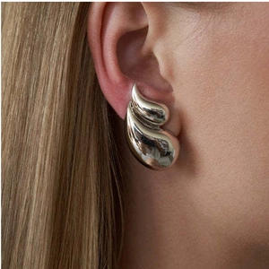 Detail view of silver teardrop chunky earrings worn by model for a modern look