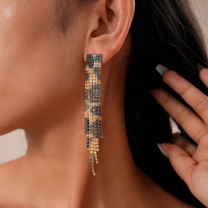 Detailed view of long leopard print fringe earrings with sparkling rhinestones on model