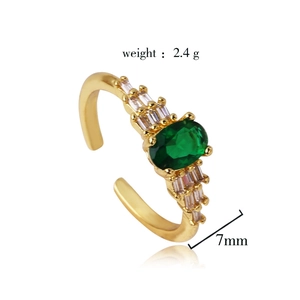 Detailed view of gold plated ring with emerald oval zircon and clear tapered stones