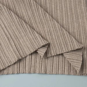 Detail of taupe ribbed knit dress showing vertical texture and high-quality hem stitching