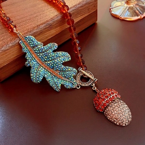 Vintage necklace with crystal leaf and acorn charms on faceted amber bead chain
