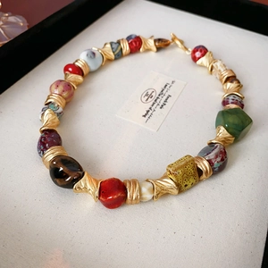 Macro view of vintage ceramic beaded necklace with colorful beads and gold textured spacers