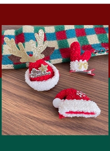 Detailed view of Christmas hair clips with plush antlers and Merry Christmas metal tags