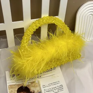 Detail of a yellow beaded handbag with ostrich feathers and translucent handles